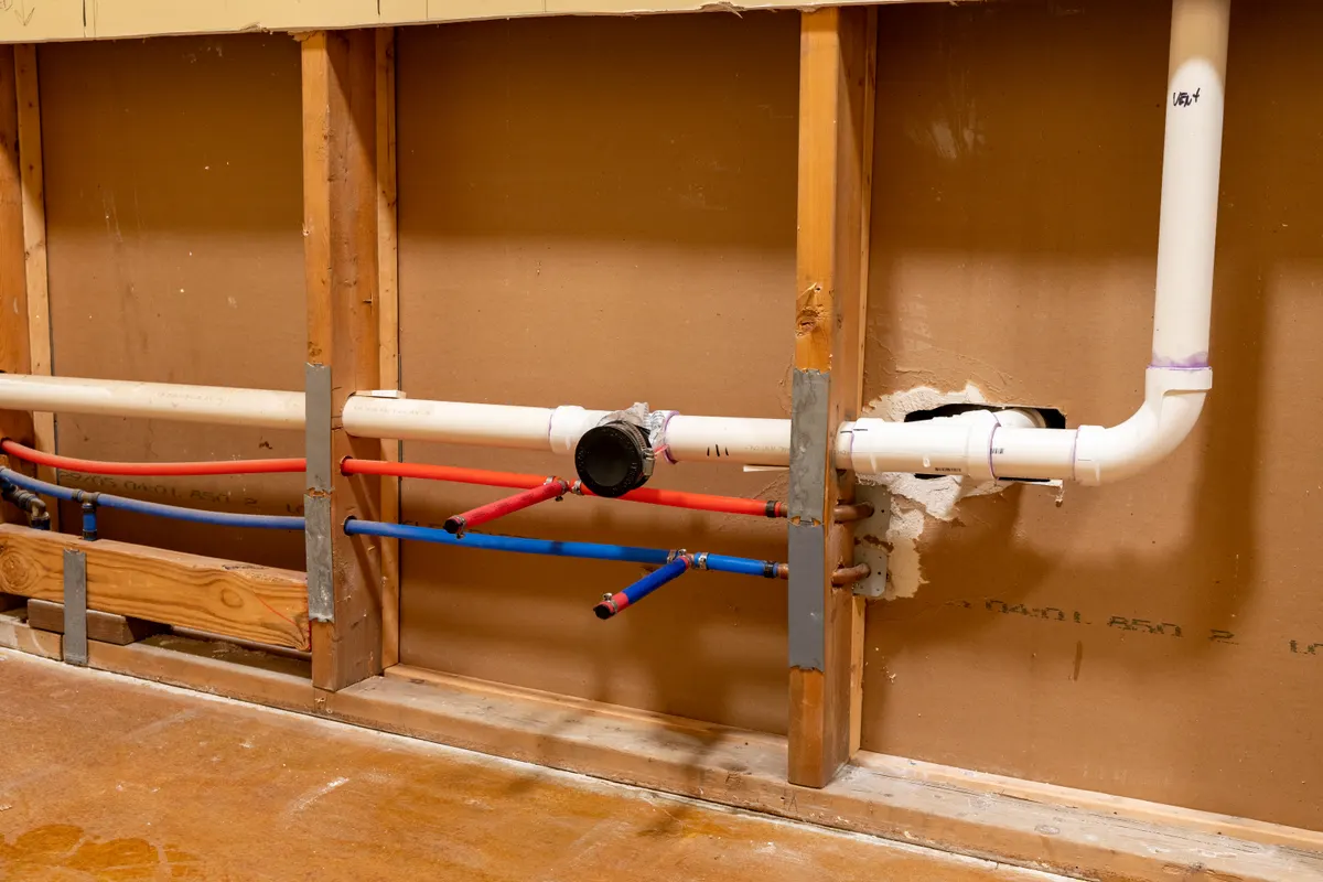 New red and blue PEX-A water lines running through wall studs