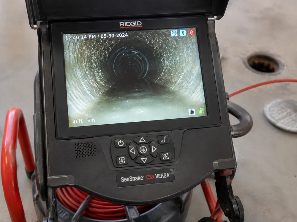 A sewer camera monitor showing the inside of a pipe during inspection