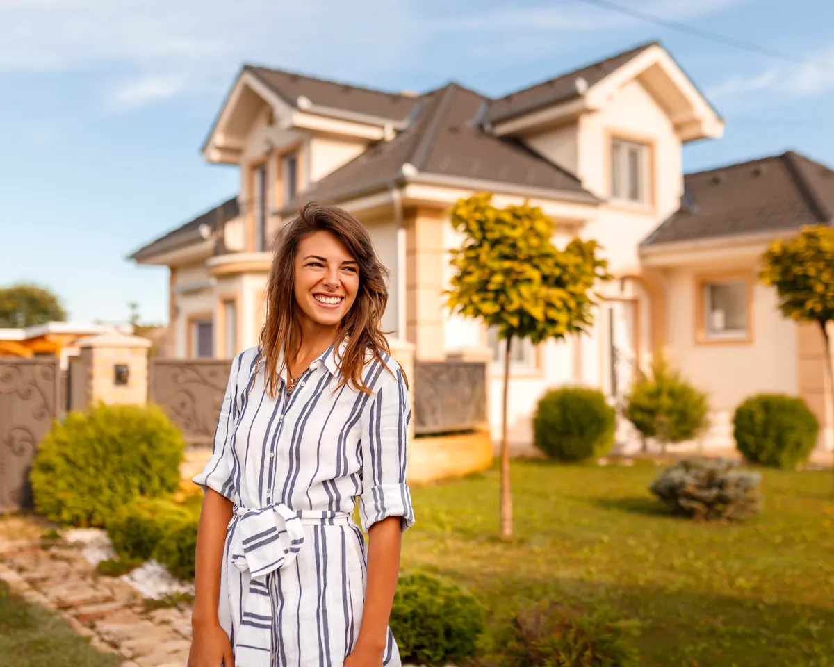 Smiling Houston homeowner standing in front of her house
